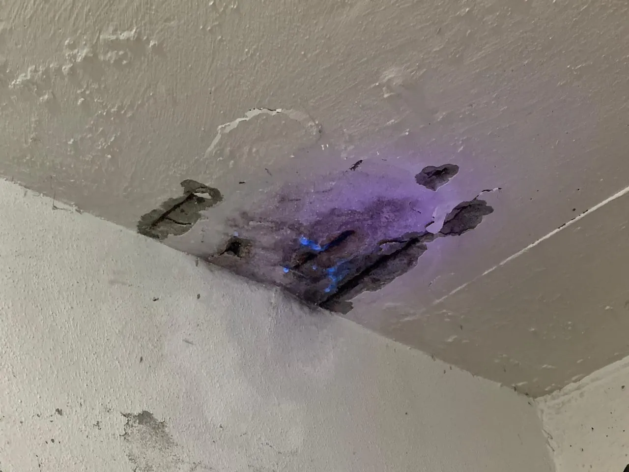 Inspeção com luz UV revelando armadura corroída em laje