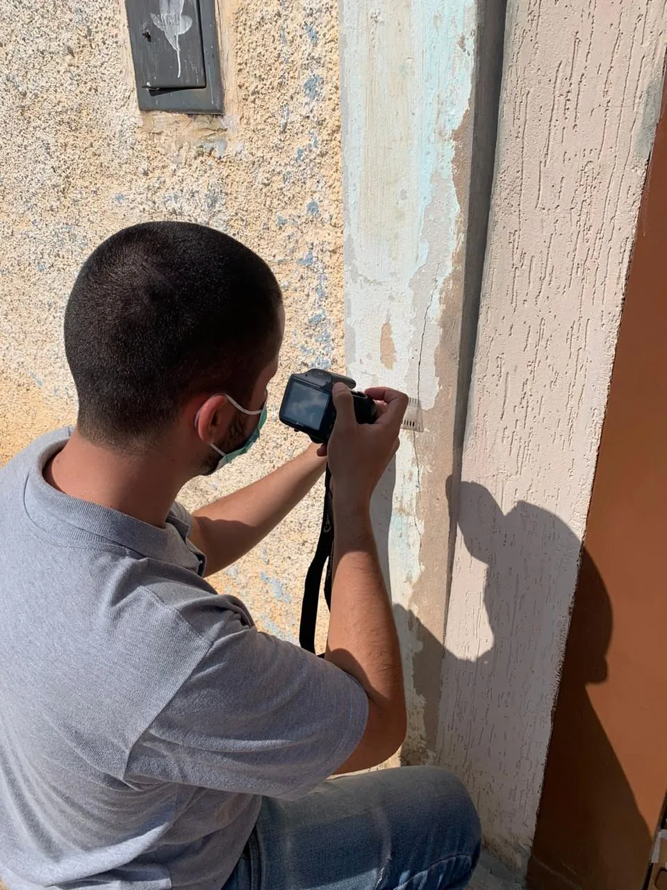 Perito registrando rachadura em parede durante diligência